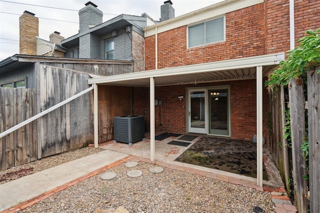 3119 W Wilshire Blvd, Oklahoma City, OK 73116 - back of house with central AC, brick siding, and a patio area