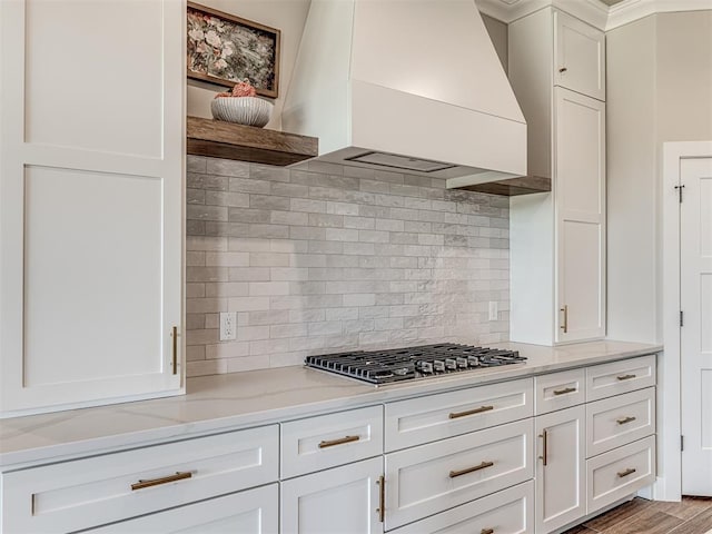6841 Lake View Ct, Cashion, OK 73016 - kitchen featuring custom range hood, stainless steel gas stovetop, open shelves, white cabinetry, and decorative backsplash