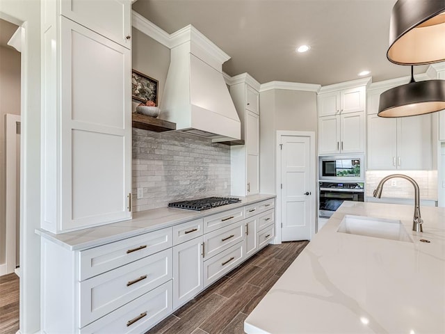 6841 Lake View Ct, Cashion, OK 73016 - kitchen with appliances with stainless steel finishes, a sink, custom exhaust hood, recessed lighting, and white cabinets