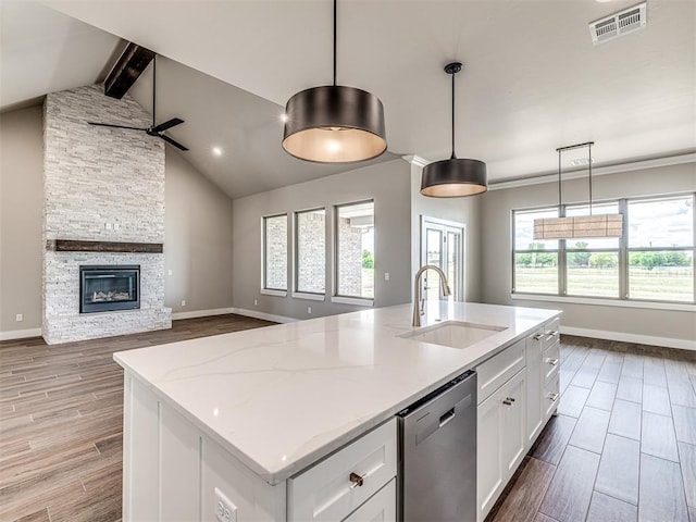 6841 Lake View Ct, Cashion, OK 73016 - kitchen with a sink, stainless steel dishwasher, open floor plan, wood finished floors, and white cabinetry
