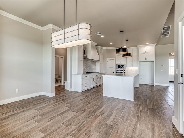 6841 Lake View Ct, Cashion, OK 73016 - kitchen with custom range hood, appliances with stainless steel finishes, baseboards, light wood finished floors, and crown molding