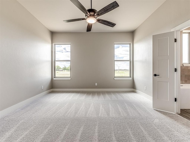 6841 Lake View Ct, Cashion, OK 73016 - empty room with ceiling fan, plenty of natural light, baseboards, and light colored carpet