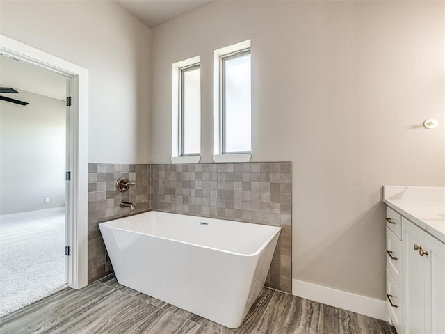 6841 Lake View Ct, Cashion, OK 73016 - bathroom with a freestanding tub, vanity, and tile walls