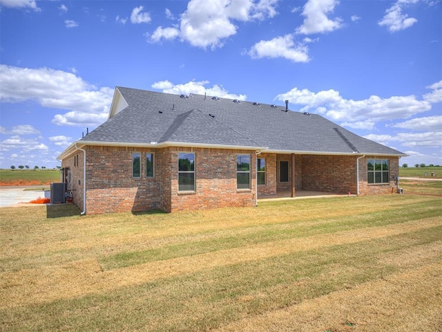 6841 Lake View Ct, Cashion, OK 73016 - back of house with a shingled roof, a patio area, brick siding, a yard, and central air condition unit
