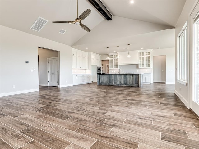 6860 Lake View Ct, Cashion, OK 73016 - unfurnished living room with beam ceiling, wood finished floors, high vaulted ceiling, a ceiling fan, and baseboards
