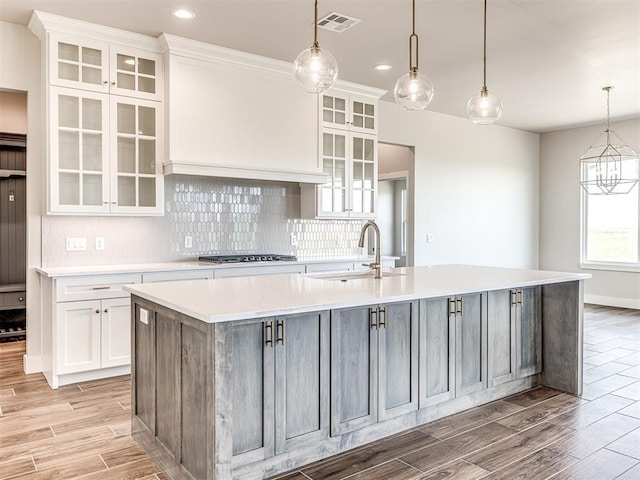 6860 Lake View Ct, Cashion, OK 73016 - kitchen with light wood-style floors, light countertops, white cabinetry, decorative backsplash, and a sink