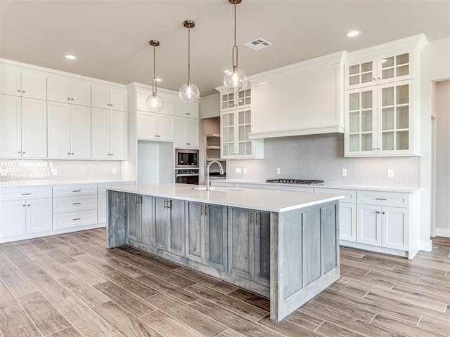 6860 Lake View Ct, Cashion, OK 73016 - kitchen with built in microwave, a sink, stainless steel oven, light wood-style flooring, and light countertops