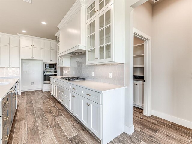 6860 Lake View Ct, Cashion, OK 73016 - kitchen with stainless steel appliances, wood finish floors, light countertops, recessed lighting, and decorative backsplash