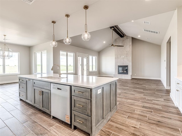 6860 Lake View Ct, Cashion, OK 73016 - kitchen featuring stainless steel dishwasher, a sink, baseboards, a tile fireplace, and wood tiled floors