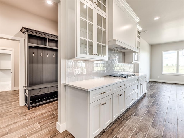 6860 Lake View Ct, Cashion, OK 73016 - kitchen with light wood finished floors, stainless steel gas cooktop, white cabinets, light countertops, and glass insert cabinets