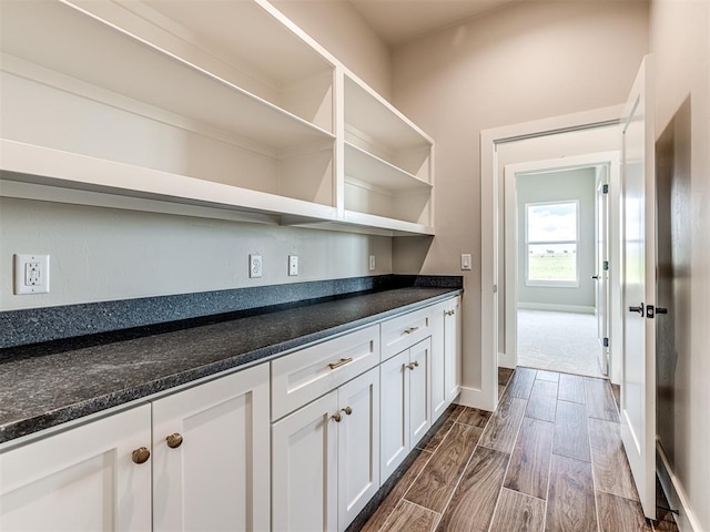 6860 Lake View Ct, Cashion, OK 73016 - kitchen featuring dark countertops, wood tiled floors, white cabinetry, open shelves, and baseboards