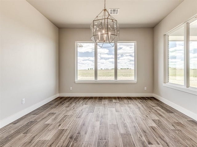 6860 Lake View Ct, Cashion, OK 73016 - empty room with a chandelier, wood finished floors, and healthy amount of natural light