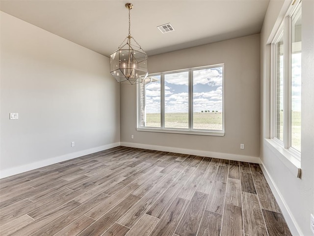 6860 Lake View Ct, Cashion, OK 73016 - spare room featuring a chandelier, wood finished floors, and baseboards