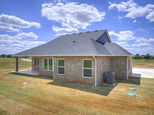 6860 Lake View Ct, Cashion, OK 73016 - rear view of house with central air condition unit, a yard, a patio area, roof with shingles, and brick siding