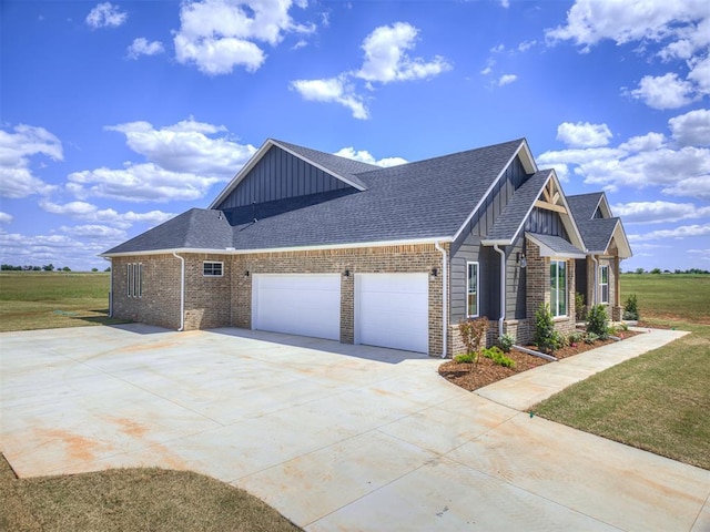 6860 Lake View Ct, Cashion, OK 73016 - view of home's exterior featuring board and batten siding, a garage, concrete driveway, and brick siding