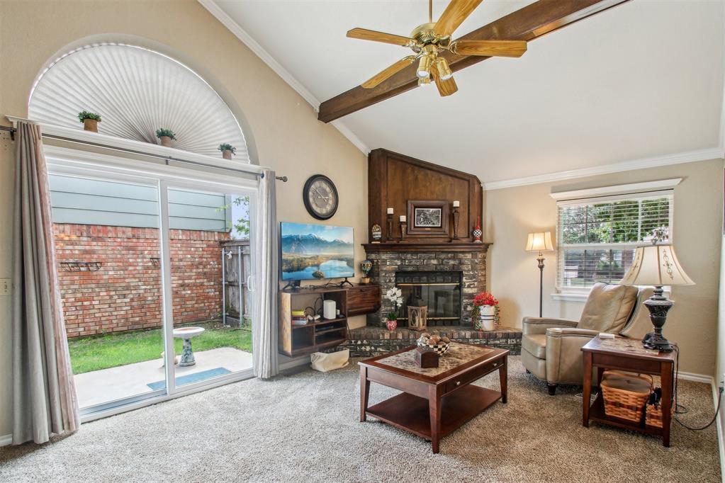 2110 Parkview Dr, Moore, OK 73170 - carpeted living area with plenty of natural light, a ceiling fan, beam ceiling, a fireplace, and high vaulted ceiling