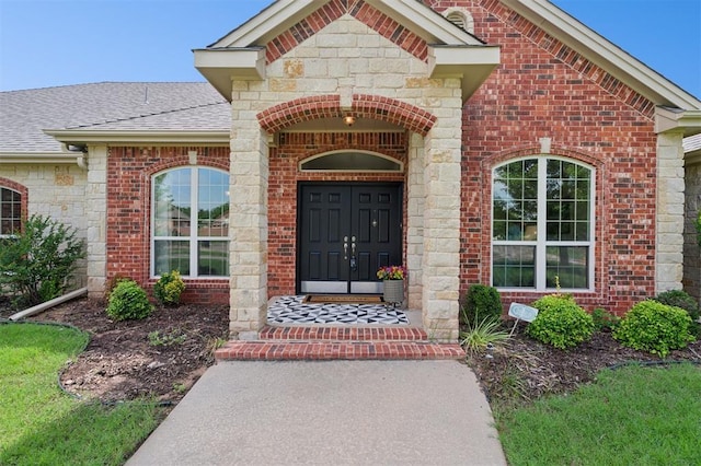 607 Pool Pl, Shawnee, OK 74801 - view of exterior entry featuring brick siding, roof with shingles, and stone siding