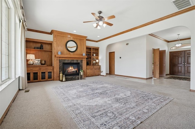 607 Pool Pl, Shawnee, OK 74801 - living area with arched walkways, light carpet, a ceiling fan, ornamental molding, and a high end fireplace