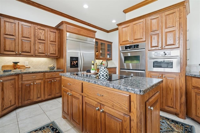607 Pool Pl, Shawnee, OK 74801 - kitchen with appliances with stainless steel finishes, brown cabinets, tasteful backsplash, ornamental molding, and dark stone countertops