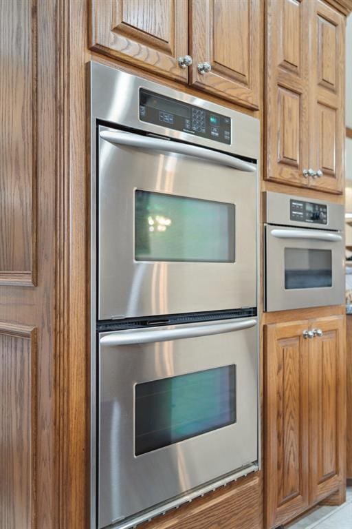 607 Pool Pl, Shawnee, OK 74801 - kitchen with stainless steel double oven and brown cabinets