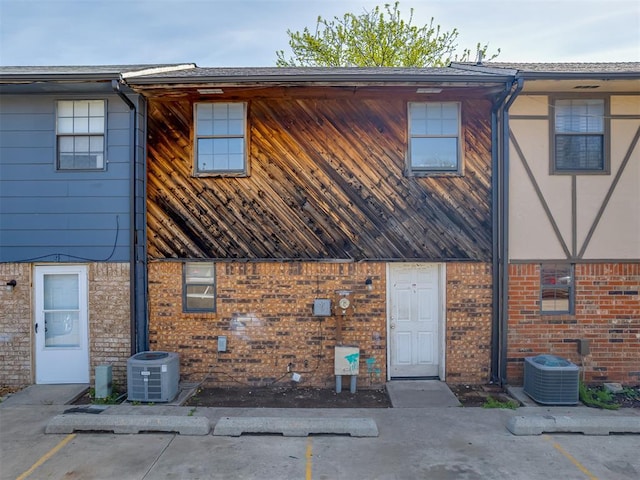 2720 SW 74th St Unit 6, Oklahoma City, OK 73159 - back of property featuring central AC unit, brick siding, and uncovered parking