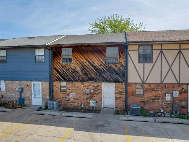 2720 SW 74th St Unit 6, Oklahoma City, OK 73159 - back of house with brick siding, uncovered parking, and central AC unit