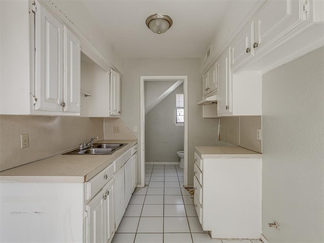 2720 SW 74th St Unit 6, Oklahoma City, OK 73159 - kitchen with a sink, light countertops, white cabinetry, and under cabinet range hood