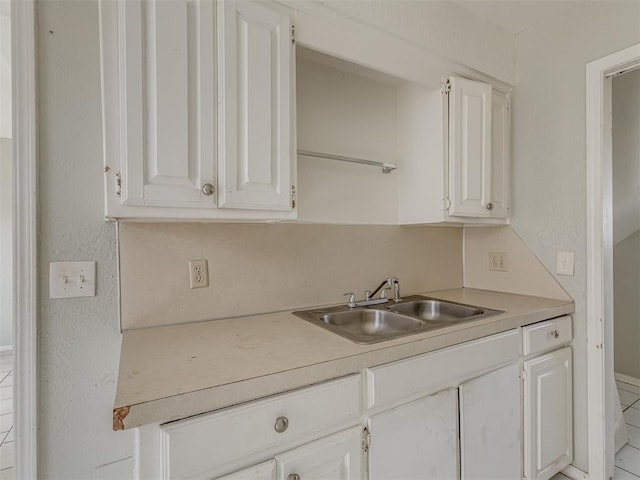 2720 SW 74th St Unit 6, Oklahoma City, OK 73159 - kitchen featuring a sink, white cabinets, and light countertops