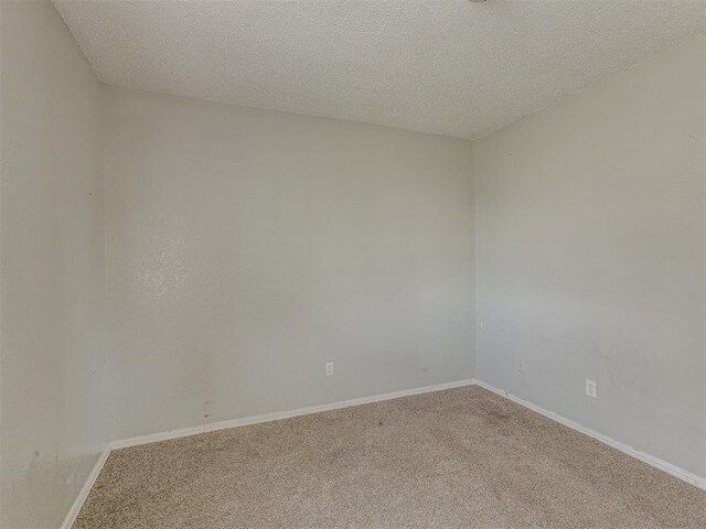 2720 SW 74th St Unit 6, Oklahoma City, OK 73159 - carpeted empty room featuring a textured ceiling and baseboards
