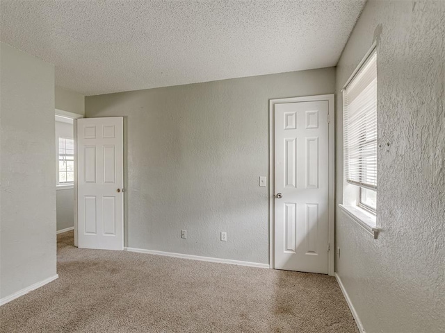 2720 SW 74th St Unit 6, Oklahoma City, OK 73159 - carpeted spare room with a textured ceiling, baseboards, and a textured wall