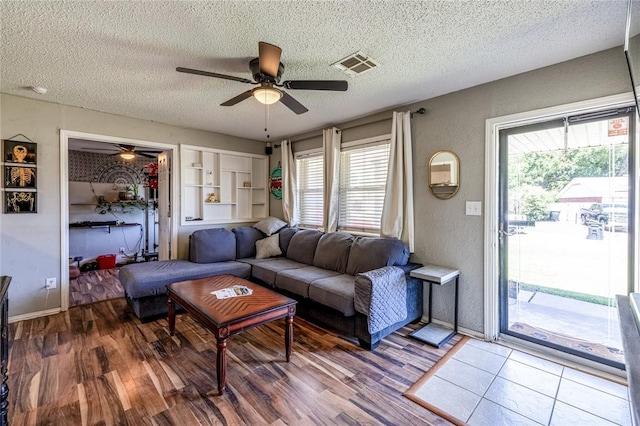 840 NW 14th St, Moore, OK 73160 - living room with a ceiling fan, a textured ceiling, wood finished floors, and baseboards