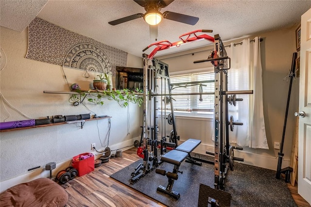 840 NW 14th St, Moore, OK 73160 - exercise area with a textured ceiling, ceiling fan, baseboards, wood finished floors, and a textured wall