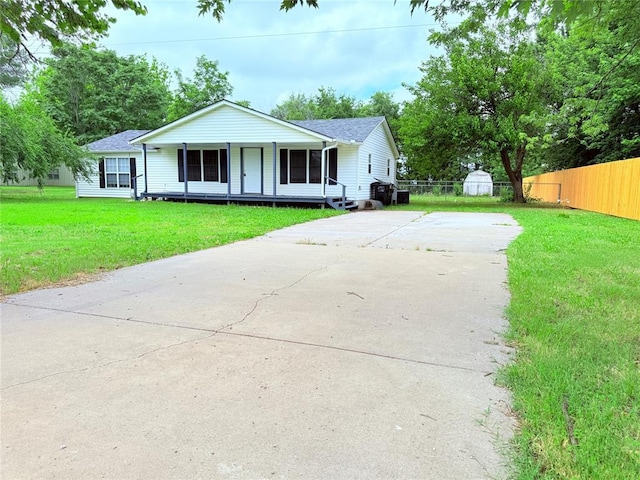 402 E 6th St, Amber, OK 73004 - single story home featuring concrete driveway, a porch, a shingled roof, and a shed