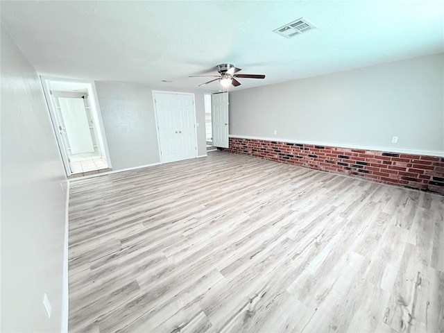 402 E 6th St, Amber, OK 73004 - unfurnished living room with wood finished floors, a ceiling fan, and brick wall