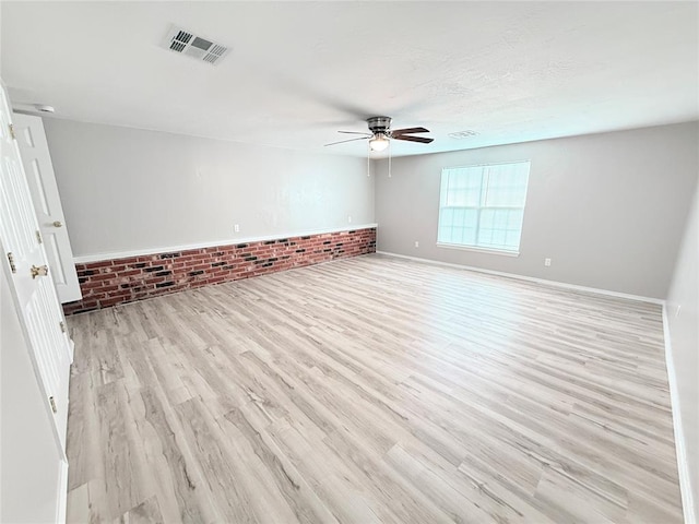 402 E 6th St, Amber, OK 73004 - unfurnished room with ceiling fan, light wood-type flooring, brick wall, and baseboards