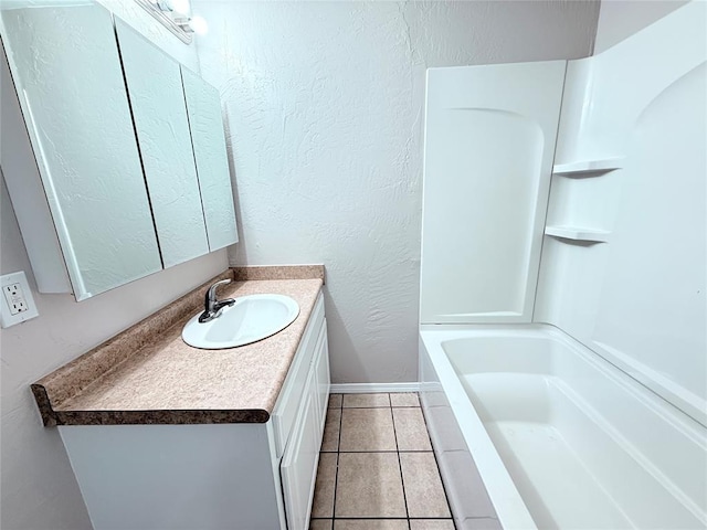 402 E 6th St, Amber, OK 73004 - bathroom featuring vanity, baseboards, a textured wall, tile patterned flooring, and shower / bathtub combination