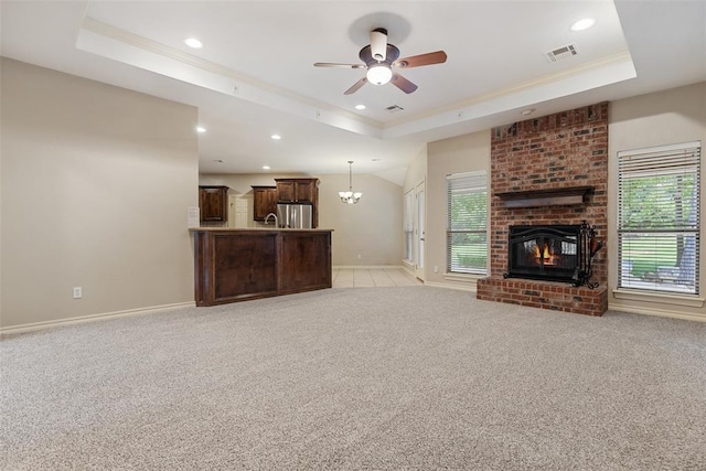 10650 Hunters Pointe, Edmond, OK 73034 - unfurnished living room featuring a raised ceiling, healthy amount of natural light, light colored carpet, recessed lighting, and ornamental molding