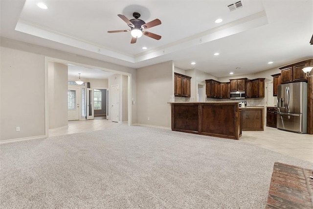 10650 Hunters Pointe, Edmond, OK 73034 - unfurnished living room featuring a raised ceiling, light colored carpet, a ceiling fan, recessed lighting, and baseboards