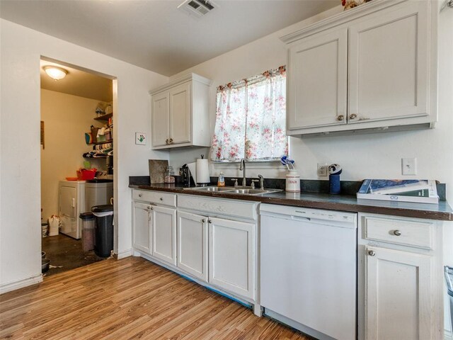 4900 S Post Rd, Oklahoma City, OK 73150 - kitchen with white dishwasher, a sink, dark countertops, light wood finished floors, and white cabinets