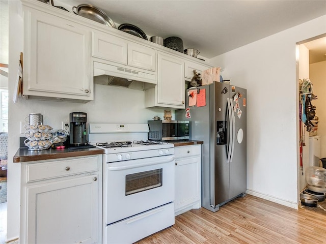 4900 S Post Rd, Oklahoma City, OK 73150 - kitchen with stainless steel appliances, under cabinet range hood, dark countertops, and light wood finished floors