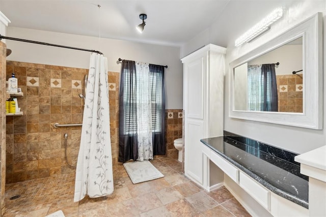 1225 Clover Rd, Moore, OK 73160 - bathroom with tile walls, toilet, a tile shower, vanity, and a wainscoted wall