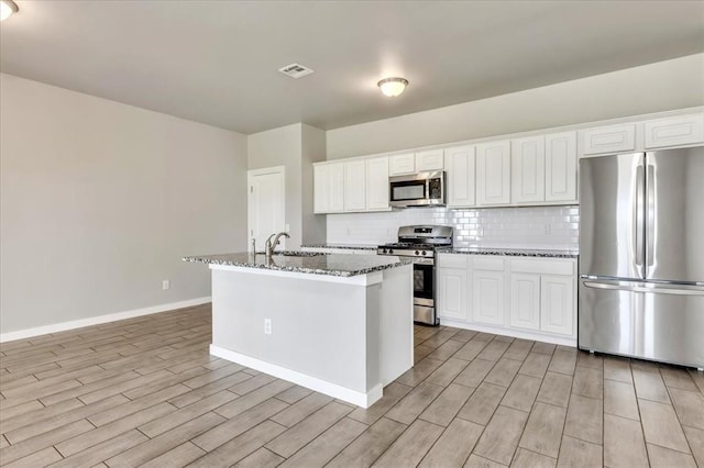 1330 Round Leaf Rd, Edmond, OK 73034 - kitchen featuring stainless steel appliances, light wood-style flooring, backsplash, baseboards, and stone countertops