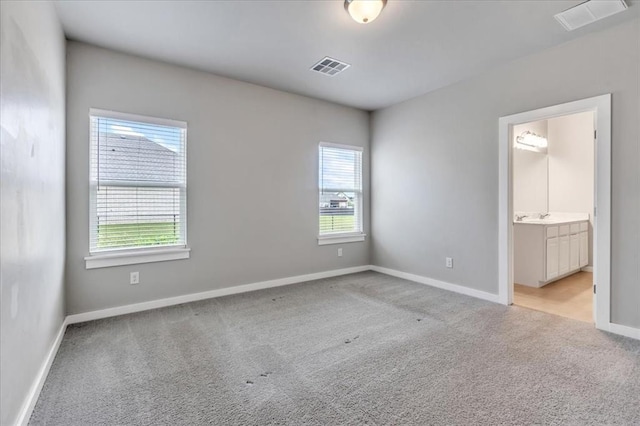 1330 Round Leaf Rd, Edmond, OK 73034 - unfurnished bedroom featuring light carpet, baseboards, connected bathroom, and a sink