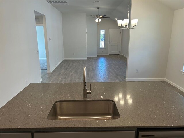 3008 NW 196th Pl, Edmond, OK 73012 - kitchen with a sink, a ceiling fan, wood finished floors, baseboards, and dark stone counters