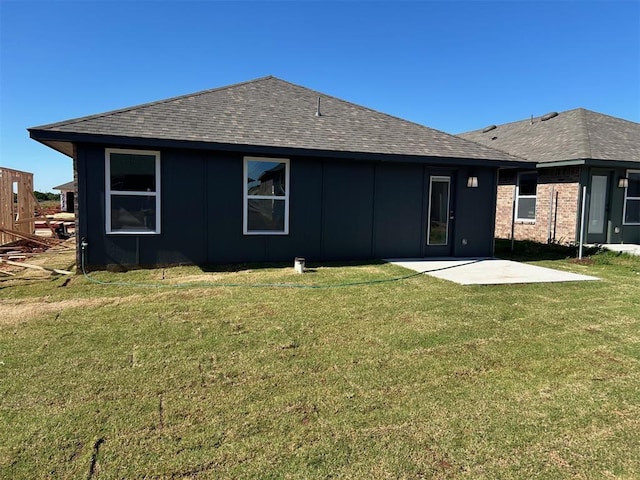 3008 NW 196th Pl, Edmond, OK 73012 - rear view of property featuring a patio, a shingled roof, a lawn, and board and batten siding