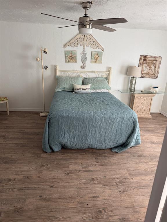 134 Wood St, Fort Cobb, OK 73038 - bedroom with wood finished floors, a textured ceiling, baseboards, and a ceiling fan
