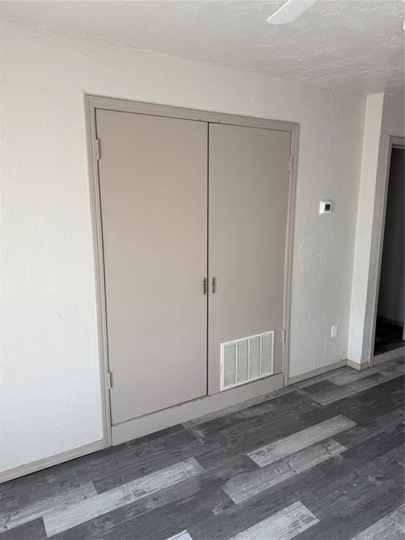134 Wood St, Fort Cobb, OK 73038 - unfurnished bedroom featuring wood finished floors, baseboards, and a closet