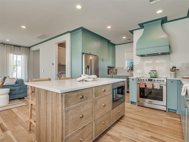 51 Lower Green Way, Carlton Landing, OK 74432 - kitchen featuring appliances with stainless steel finishes, custom exhaust hood, light wood finished floors, tasteful backsplash, and recessed lighting