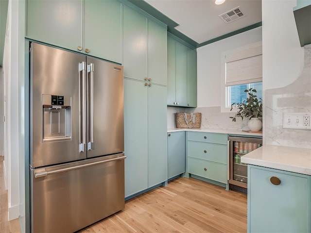 51 Lower Green Way, Carlton Landing, OK 74432 - kitchen featuring high end fridge, beverage cooler, green cabinets, light countertops, and light wood-style flooring