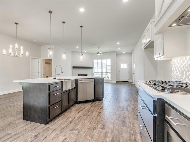 1241 SW 139th St, Oklahoma City, OK 73170 - kitchen featuring appliances with stainless steel finishes, a sink, a ceiling fan, baseboards, and light wood-style floors